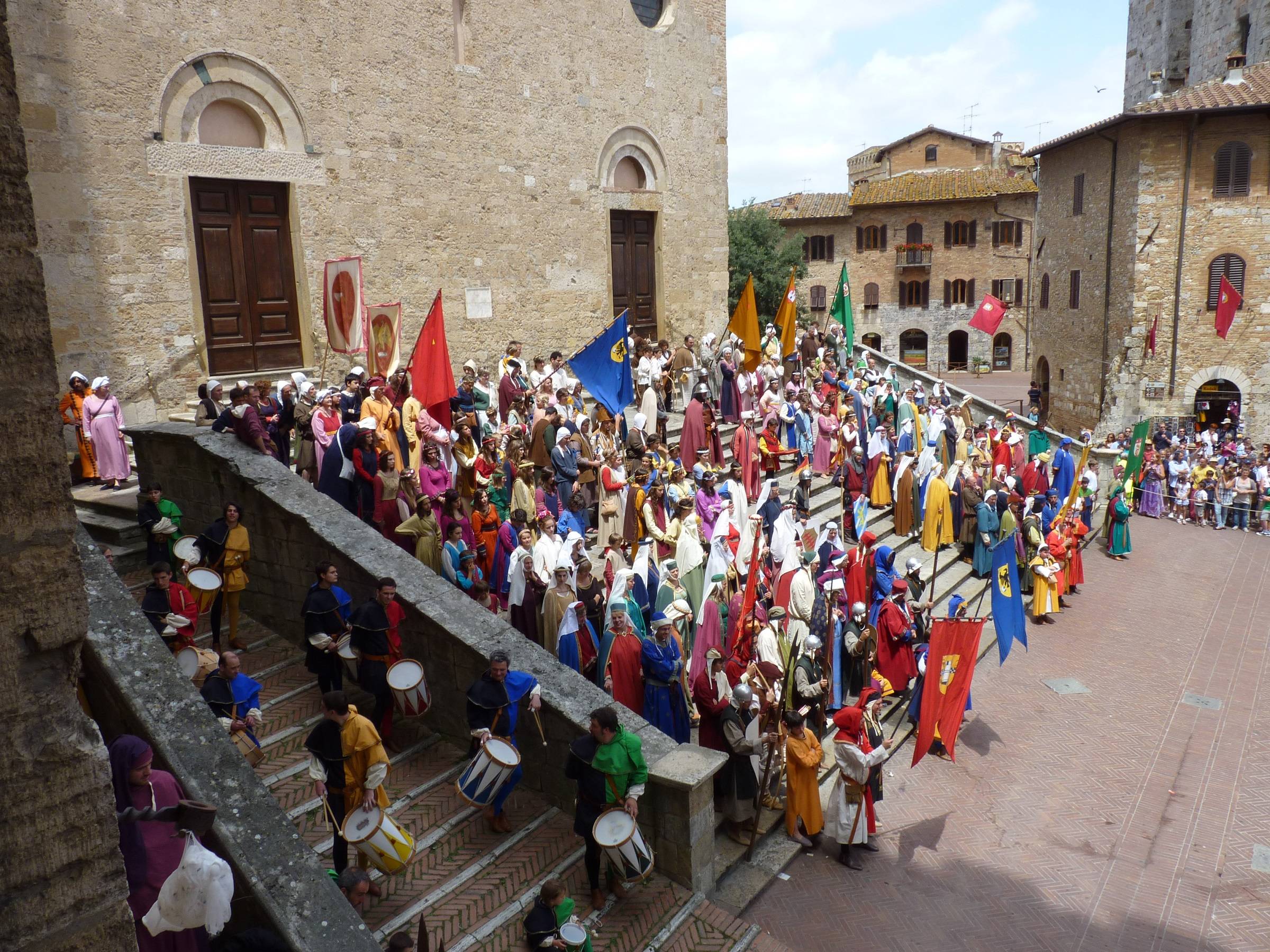 Piazza d'uomo con figuranti vestiti secondo l'uso medievale per le Ferie delle Messi a San Gimignano